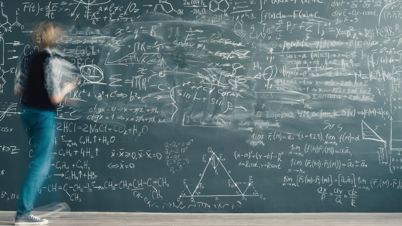 Student working on a chalkboard covered in math equations
