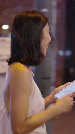 woman using phone in the city at night
