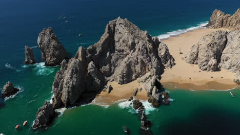 cinematic drone shot of sea cliffs with playa del amor and el arco in view in cabo san lucas mexico, descending slowly