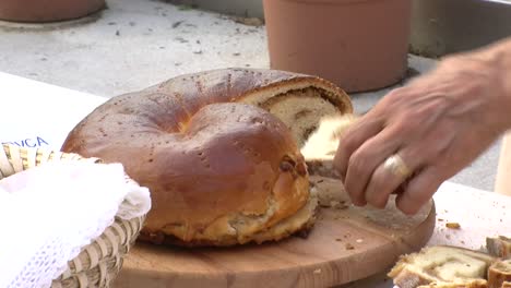 Alte-Frau-Schneidet-Potica-Mit-Messer,-Nahaufnahme-Von-Slowenischem-Kuchen-Auf-Holzbrett