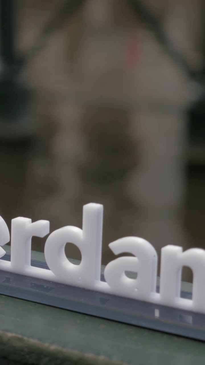 Valkoinen joutsen vedessä ja "I amsterdam" -slogan