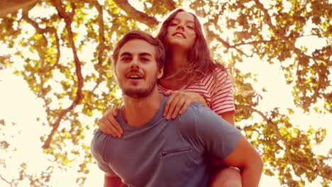 hombre guapo haciendo piggy-back a su novia
