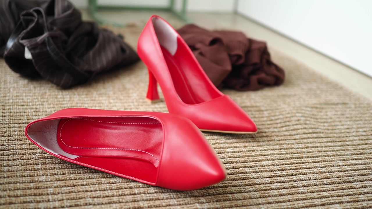 Stylish Red High Heels Resting on a Textured Rug