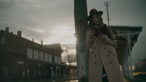 mujer con sombrero leyendo al aire libre