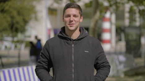 Handsome-young-man-talking-at-camera-outdoor