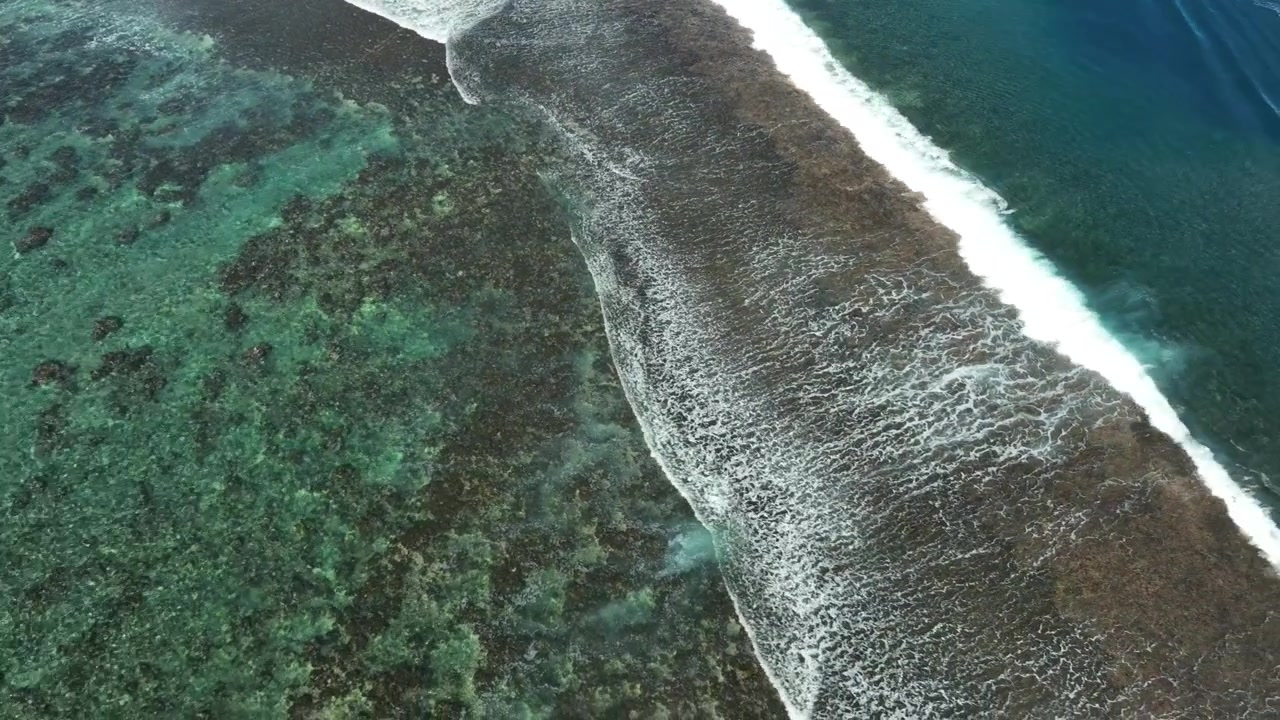 Clear ocean waves flowing across vibrant reef at Teahupo’o, Tahiti.