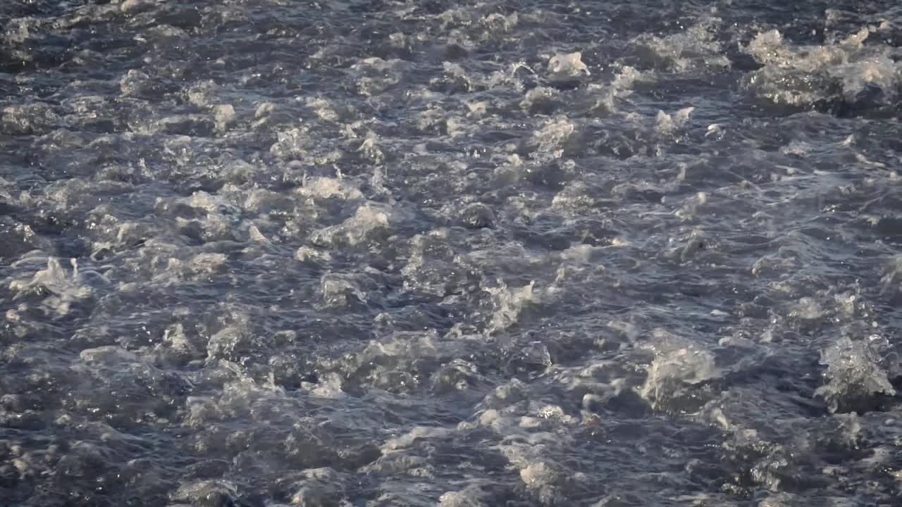 테네리페에서 바다로 다시 흘러갈 때 바위 위로 흐르는 물의 슬로우 모션 보기