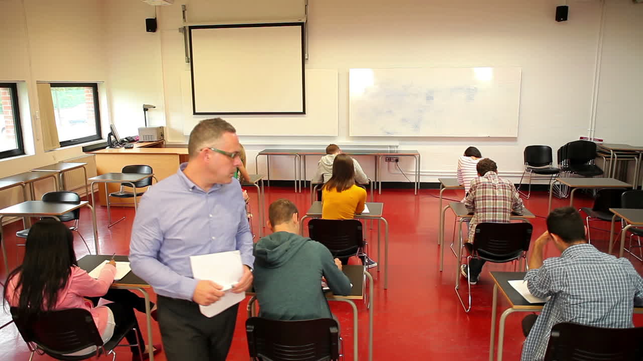 Lecturer walking around his class during a test