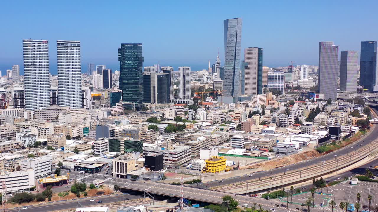 Aerial view of the modern Tel Aviv cityscape, featuring numerous skyscrapers and a busy highway