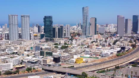 aerial view of the modern tel aviv cityscape, featuring numerous skyscrapers and a busy highway
