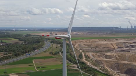 una turbina eólica solitaria cerca de la mina garzweiler, con vistas a la autopista