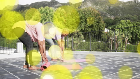 people rolling yoga mats on outdoor terrace with glowing yellow circles animation