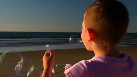 child blowing bubbles on a sunny beach
