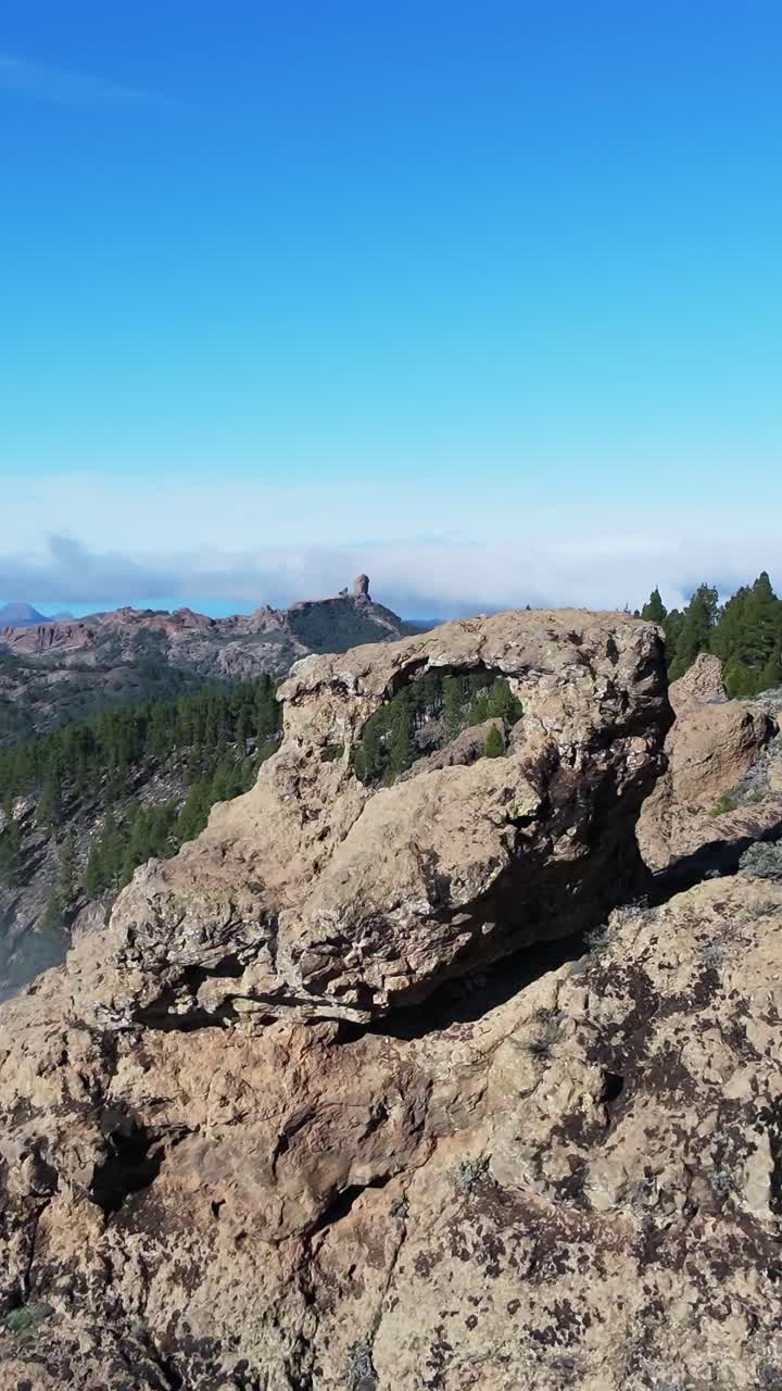 Ripresa aerea con drone che rivela la formazione rocciosa Ventana del Nublo, con l'iconico Roque Nublo visibile nello sfondo montuoso