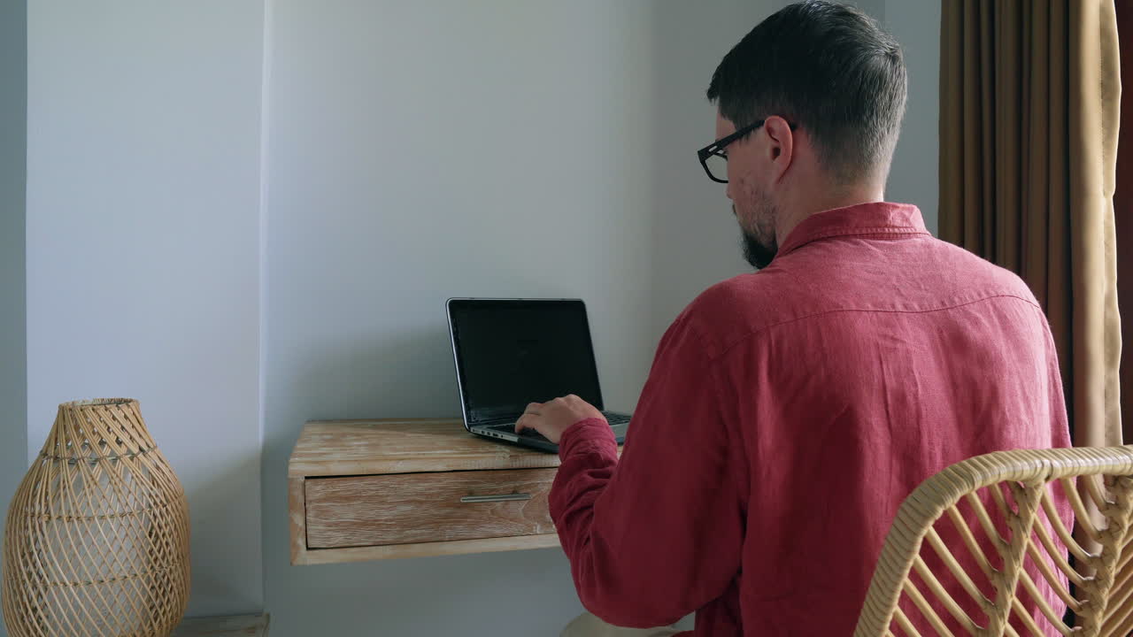 hombre trabajando en una computadora portátil en casa