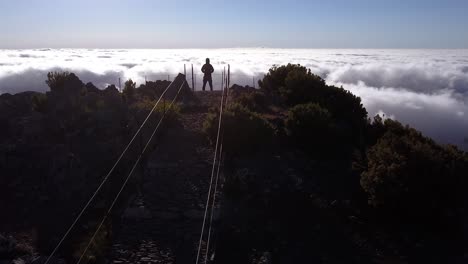 Stunning Aerial View of Person Standing Above Clouds on Mountain Peak
