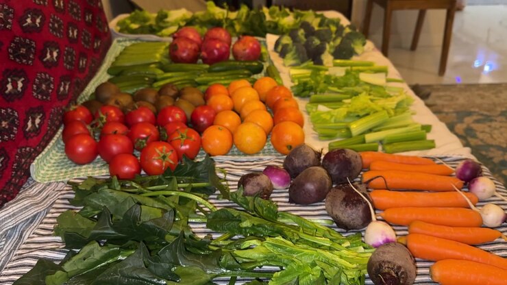 Fresh organic agriculture product and vegetables spinach tomato cucumber carrot beetroot lettuce celery colorful vibrant on Persian Iranian carpet pattern rustic flatlay overhead still life in kitchen