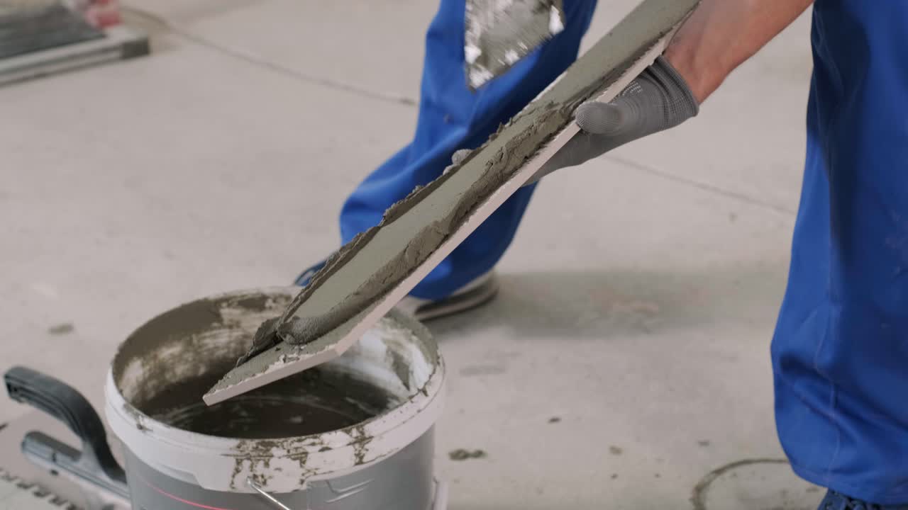 Installing ceramic floor tiles - measuring and cutting the pieces. Construction, renovation, repair apartment. Cuts tile. Tile cutting