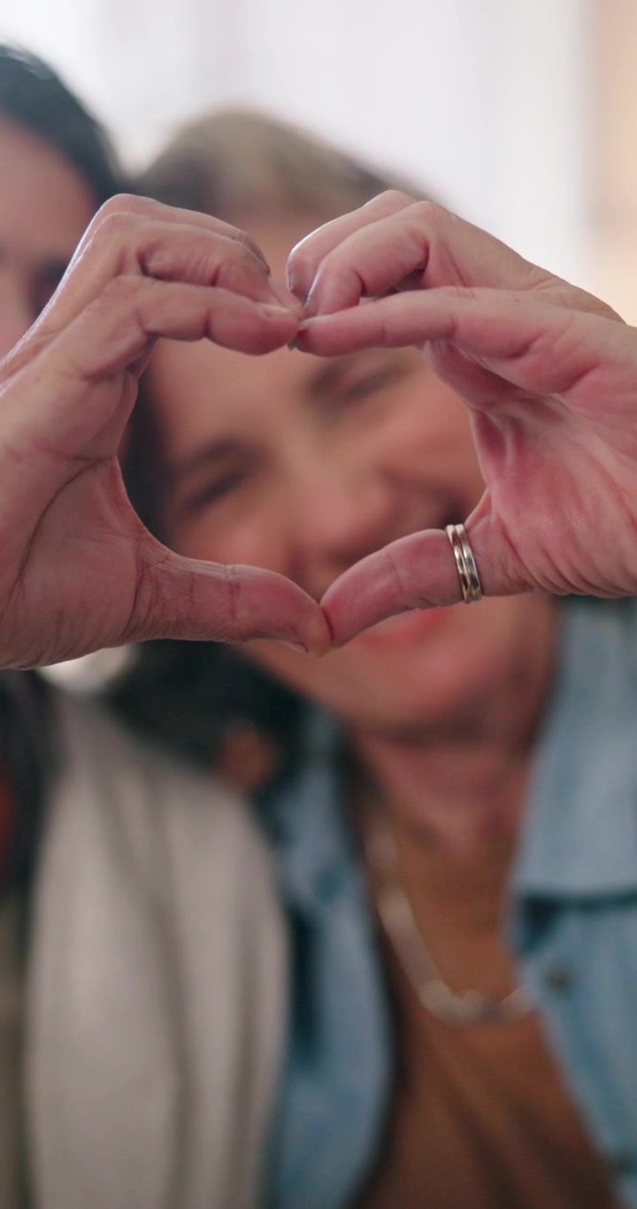 Due donne che formano un cuore con le mani