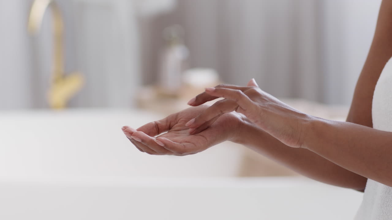 Kvinna applicerar lotion i badrum