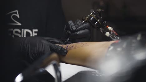 tattoo artist applying tattoo on client's arm