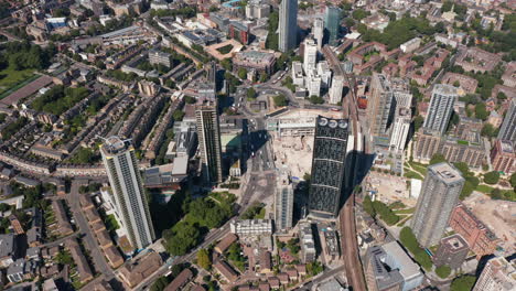 Aerial-shot-of-group-of-skyscrapers-at-Elephant-and-Castle.-Tall-modern-Strata-apartment-building-with-wind-turbines-on-top.-London,-UK