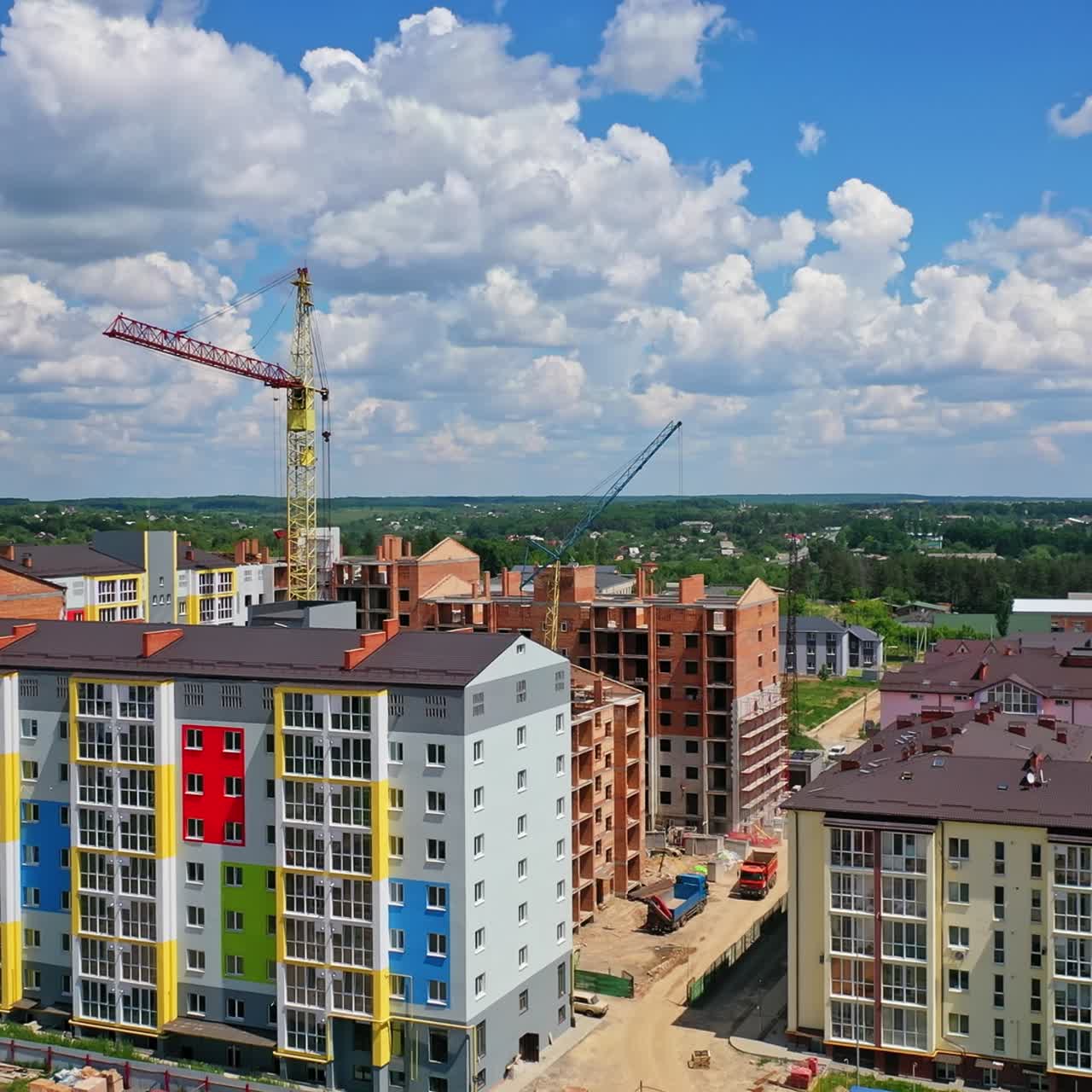 Building of a modern district. Construction site of new complex with high rise buildings. Colorful apartment building in new microdistrict