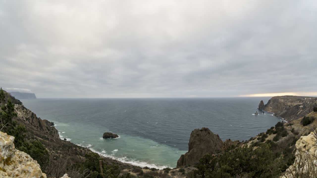 timelapse en un día nublado con nubes cumulonimbus de lluvia y nieve, moviéndose a través del cielo a diferentes alturas, con efecto de paralaje sobre la laguna marina y las colinas rocosas. concepto de viaje de naturaleza y al aire libre
