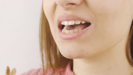 woman eating peanut in close-up. hazelnut.