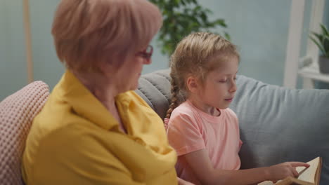 Girl reads story and looks at senior woman seeking approval