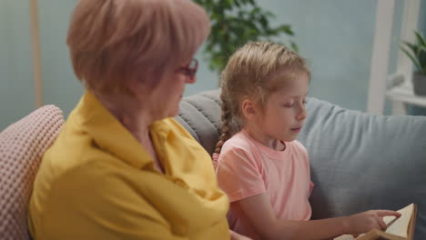 girl reads story and looks at senior woman seeking approval