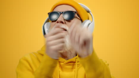 joyful elderly man gesturing in modern studio. stylish guy having fun indoors.