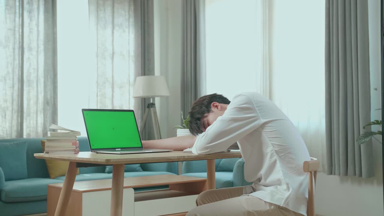 Side View Of Asian Man Student Sleeping While Using Green Screen Computer At Home