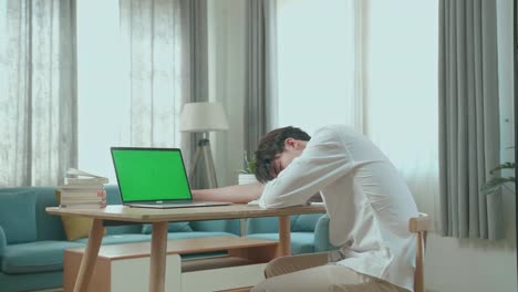 side view of asian man student sleeping while using green screen computer at home