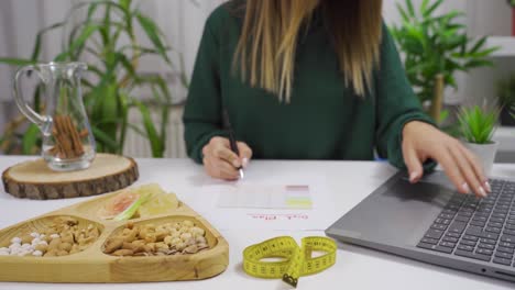 la mujer prepara un programa de dieta para sí misma en casa. estilo de vida saludable.