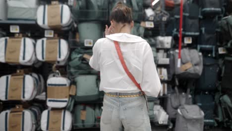 woman shopping for backpacks and bags in a store