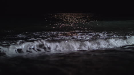 dark foamy waves washing the seashore at night