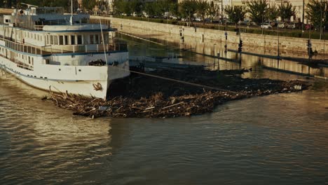 large boat caught in a pile of floating debris on the danube, budapest flood 2024