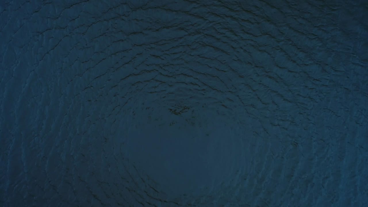 círculo de agua girando y extendiendo la superficie de movimiento en la sombra azul.