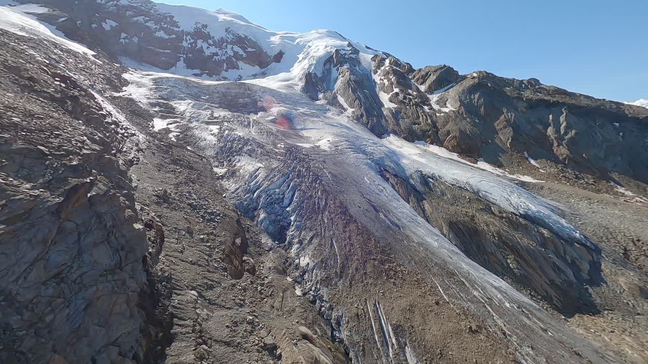 FPV drone flying through the exposed Weismies glacier above Saas-Grund, revealing deep crevasses, seracs, and signs of rapid glacial melt. The Swiss Alps in all its beauty