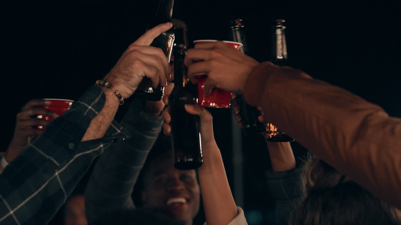 grupo de amigos haciendo brindis bebiendo cerveza disfrutando de la fiesta en la azotea celebrando por la noche personas multiétnicas jóvenes divirtiéndose socializando pasando el fin de semana