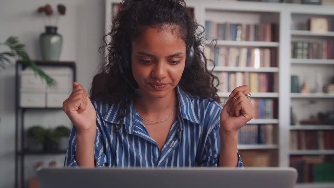 Young indian woman in wired headset is nervous during work sits in office
