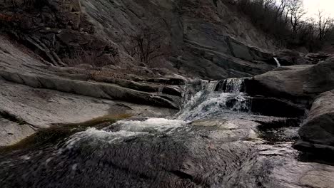 vuelo cercano vuelo de drones sobre el agua cerca de una cascada durante el día