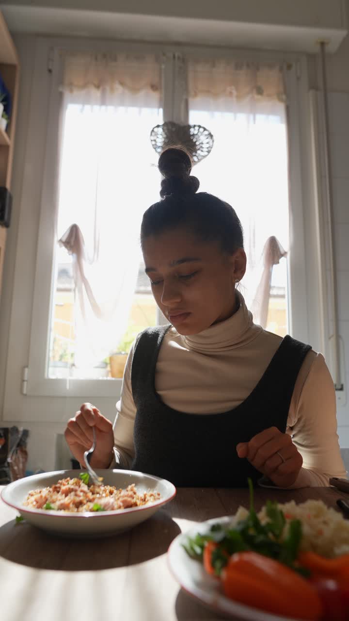 mujer comiendo pasta en la cocina