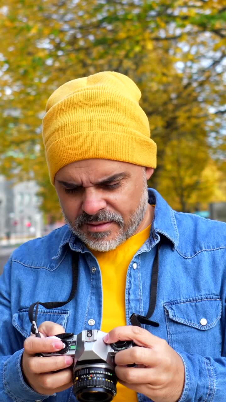Man with analog camera in autumn