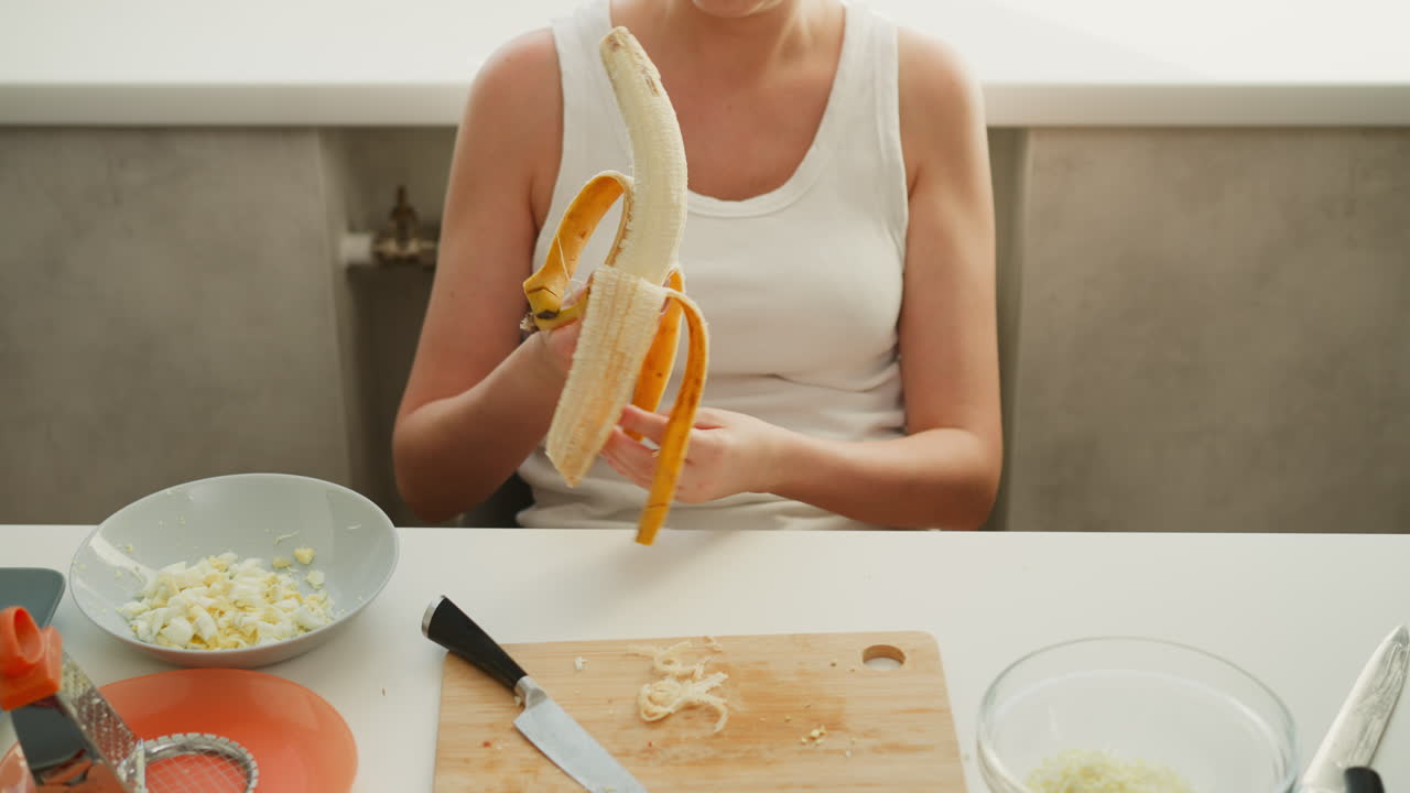 Donna che sbuccia una banana in cucina