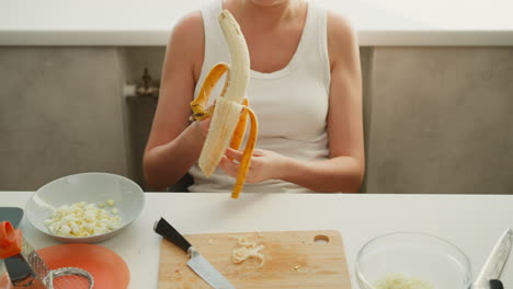 woman peeling a banana in a kitchen