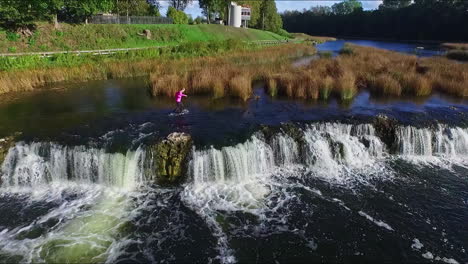 Aerial-View-Of-Woman-Walking-On-The-River-Flowing-To-Venta-Rapid-In-Latvia