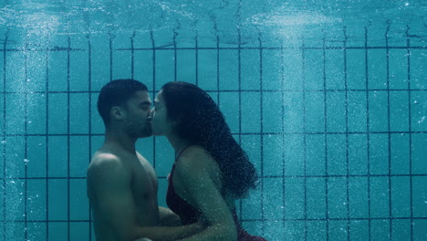 romantic couple kissing underwater in swimming pool young people in love enjoying intimate kiss lovers submerged in water floating with bubbles in passionate intimacy