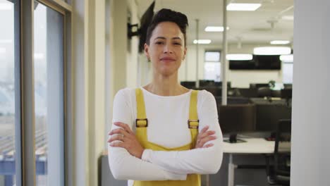 retrato de una mujer de negocios creativa caucásica con las manos cruzadas mirando a la cámara y sonriendo